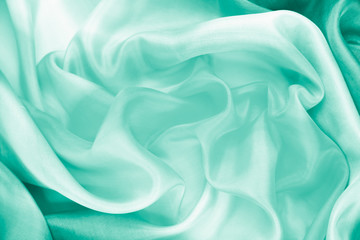 Obraz premium The texture of the satin fabric of green color for the background 
