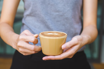 beautiful girl hold delicious hot coffee cup serving for your freshness.