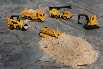 Toy models of construction equipment in transporting sawdust