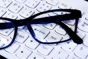 Academic concept and technology close-up glass and keyboard. 