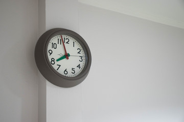 Modern clock hanged on the white wall.