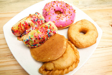 Colorful and tasty donuts on a wooden background