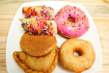 Colorful and tasty donuts on a wooden background
