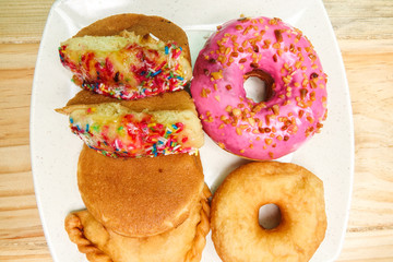 Colorful and tasty donuts on a wooden background