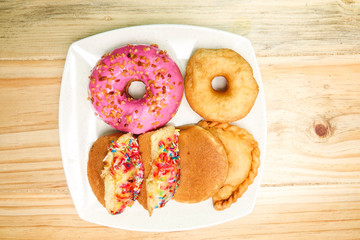 Colorful and tasty donuts on a wooden background