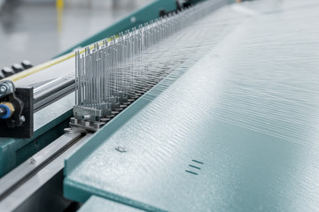 macro shot of a stretched thread. machinery and equipment in a textile factory