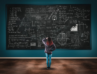 Confused girl in front of a blackboard full of formulas..