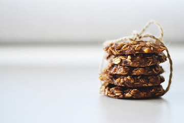Stack of banana cookies tied with rope on white background