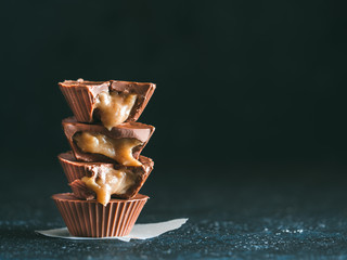 Stack of vegan chocolate cups with caramel on white