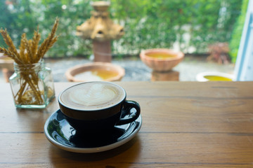 Closeup latte art of coffee white cup on wooden table surface