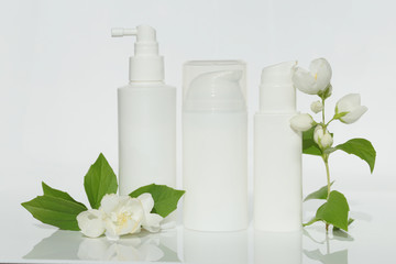 jasmine extract. cosmetics with jasmine extract in white bottles and jasmine flowers  on a white background.cosmetic mockup white bottles with copy space