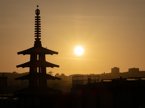 Silhouette of Peace Pagoda in San Francisco, CA while sun is setting to right