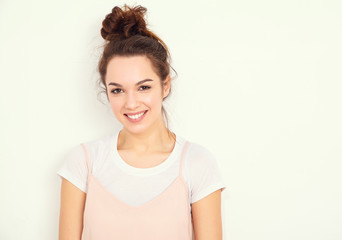 Fototapeta premium Portrait of young beautiful brunette woman girl model with nude makeup in colorful summer pink hipster clothes posing near wall. Going crazy and looking happily in camera