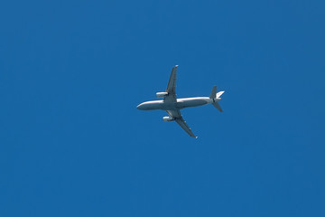 the plane is flying against the blue sky.