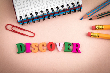 Discover. Wooden letters on the office desk, informative and communication background