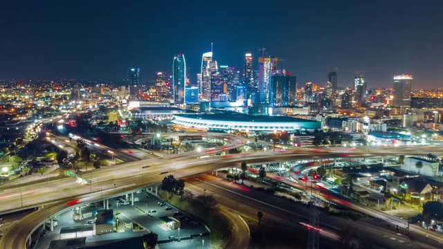 Cinematic aerial hyper lapse ( time lapse in motion ) of skyscrapers of Downtown Los Angeles, Conventional Center  and 10 & 110 freeways traffic at night