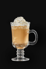 Single-color opaque cocktail, coffee with milk, cocoa, hot chocolate in a tall glass with a handle with whipped cream. Side view. Isolated black background. Drink for the menu restaurant, bar, cafe