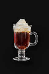 Single-color transparent cocktail, coffee, tea in a high glass with a handle with whipped cream. Side view. Isolated black background. Drink for the menu restaurant, bar, cafe
