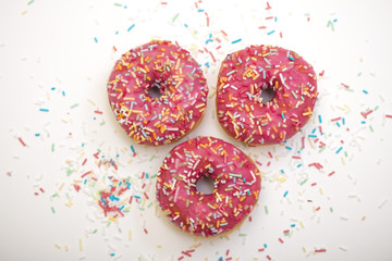 pink donuts with sprinkles on white 