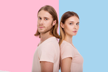 United in difference. Pretty young woman and her boyfriend with a longish hair standing back to...