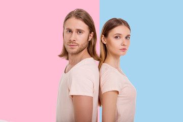 Powerful together. Charming young woman and her boyfriend standing back-to-back and looking at the...