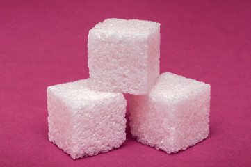 macro shot of a 3 cubes of sugar on a colored surface