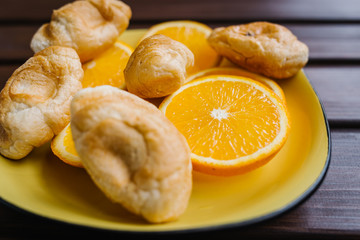 Croissants with oranges and on rustic wooden table