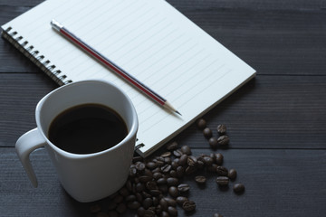 A cup of coffee and a notepad with pencil
