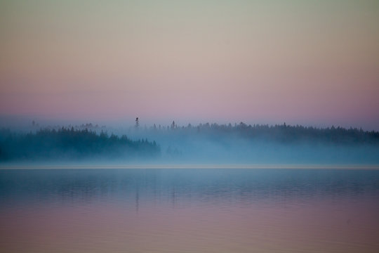 mist over the lake and taiga forest