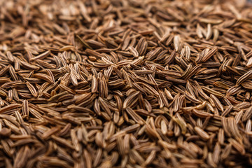 Seeds of cumin on a dark stone background