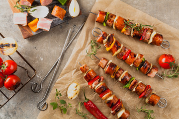 Grilled skewers with sausage, bacon and vegetables.