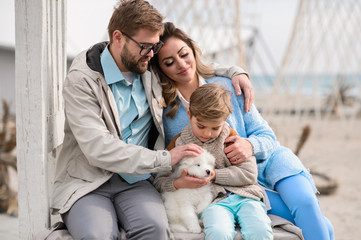 Obraz premium Happy family on a beach. The family walks on a beach with a dog.