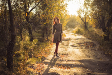 the girl is walking at sunset