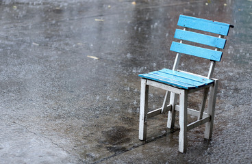 lonely blue chair in the rain, feeling sad, bad mood in bad day,alone chair