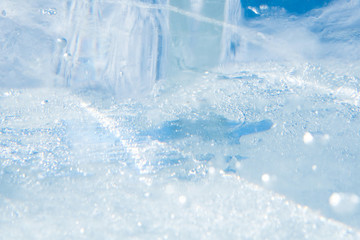 Fototapeta na wymiar Beautiful blue texture of transparent winter ice with rainbow colors
