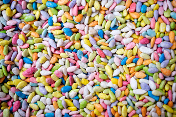 food, junk-food, confectionery and unhealthy eating concept - close up of multicolored dragee candies