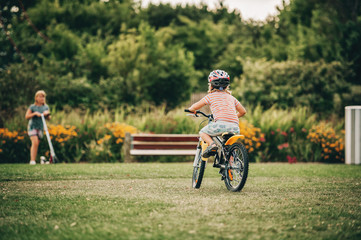 Cute little boy riding bicycle in the park, sport for children, active family outside