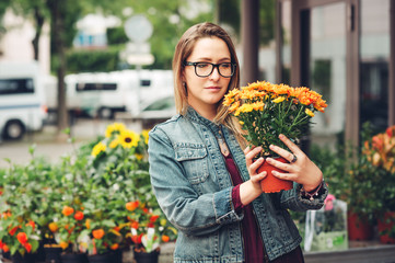 Woman buying flowers in pots in flower shop