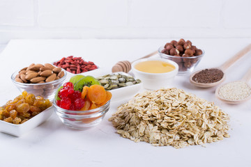 Ingredients for homemade oatmeal granola. Oat flakes, honey, nuts, dried fruit and seeds. Healthy breakfast concept.