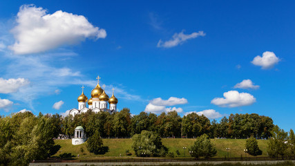 Fototapeta na wymiar Landscape. Temple with golden domes against the blue sky.