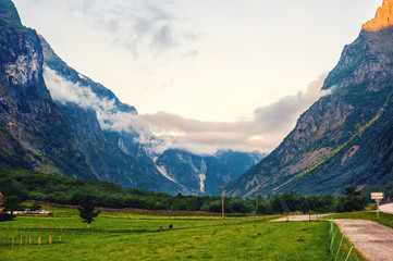Obraz premium Beautiful views of the sunrise over the fjord and mountains from the bridge in the Norwegian village of Gudvangen.