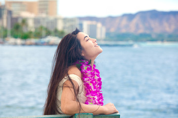 Fototapeta premium Hawaiian teen with lei sitting by ocean, Waikiki in background