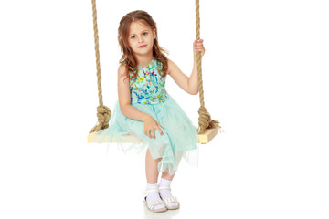 Little girl swinging on a swing