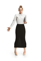 Fototapeta premium Full length portrait of a surprised female teacher holding a folder isolated against white background