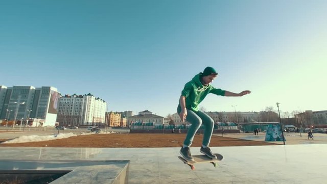 Professional skateboarder doing kickflip trick on the city street