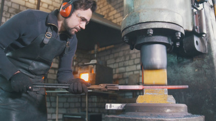 Blacksmith forging red hot iron on anvil - automatic hammering