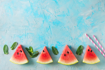 Frame of watermelon slices and mint on blue texture