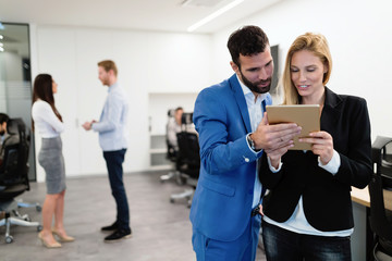 Attractive business couple using tablet in their company