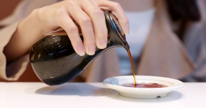 Pouring soy sauce into plate