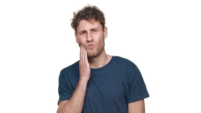 Portrait of disappointed man suffering from toothache with touching cheek and expressing pain on face, isolated over white background. Concept of emotions